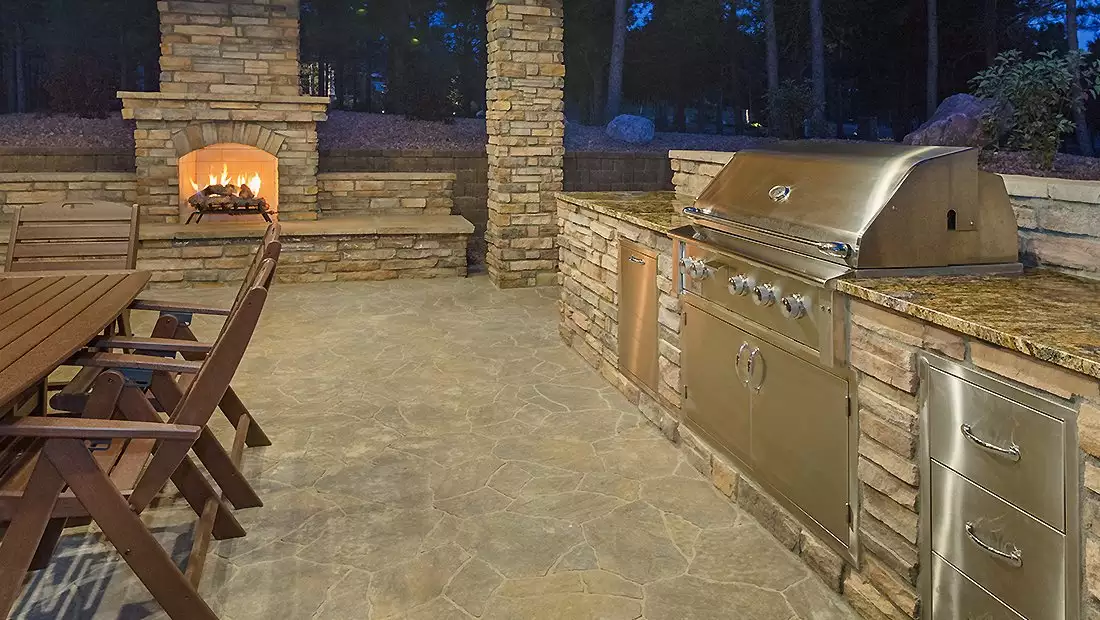 Backyard Tiled Space with Dining Table, Grill/Kitchen, and Fireplace
