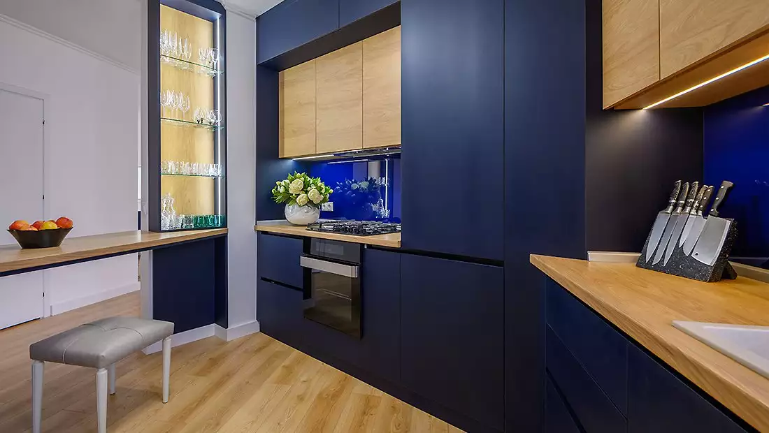 Modern Kitchen Area featuring Dark Blue and Light Wood Cabinets