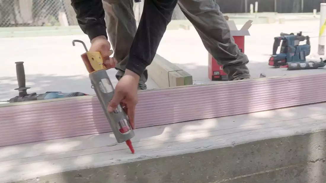 Seal Application with Caulk Gun on the Base of the Austin Build House